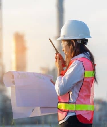 Female engineer talking on radio at an industry site